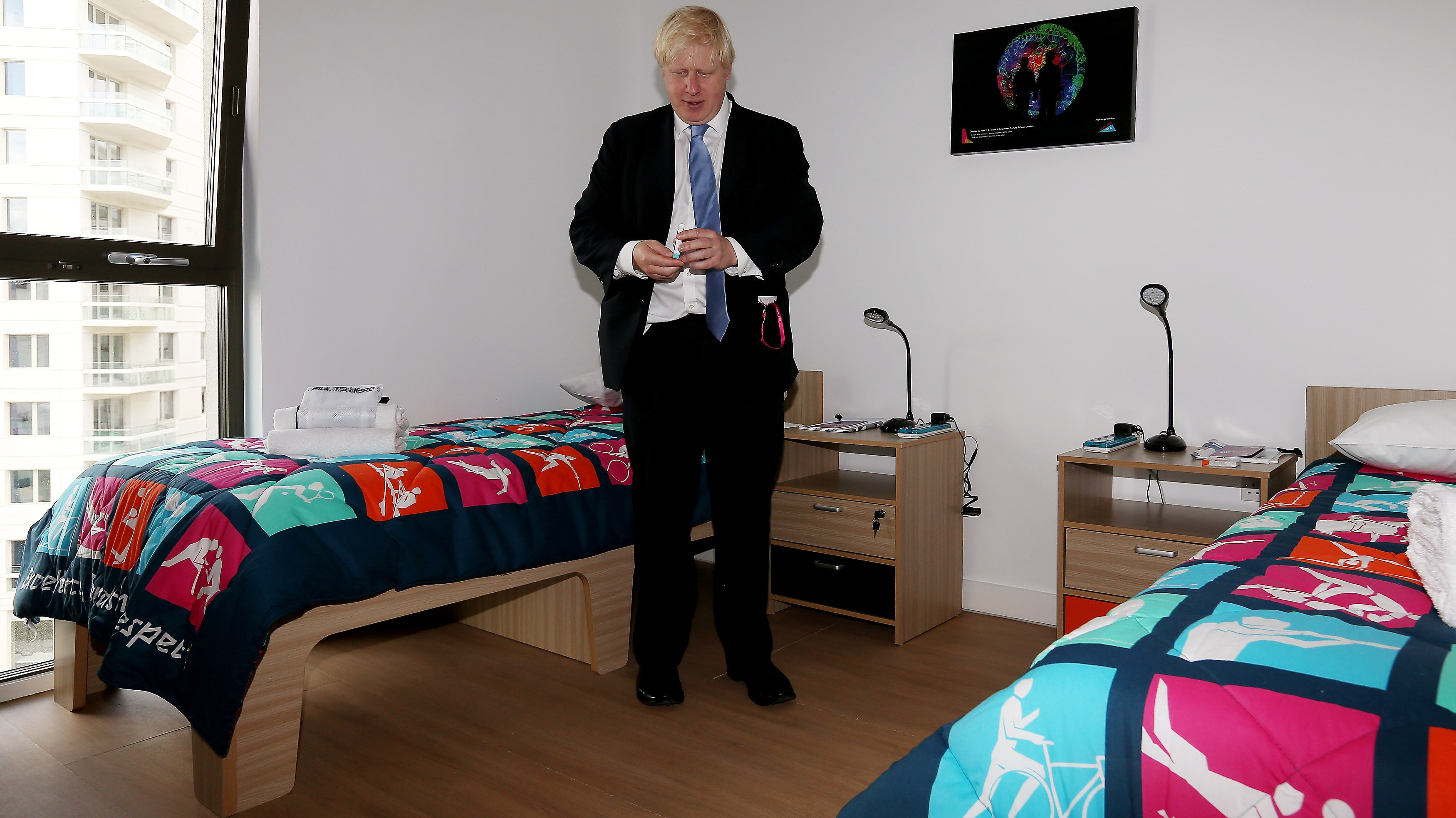 London Mayor Boris Johnson picks up a packet of Olympic branded condoms during a visit to the Olympic Village last month. Durex, the official Olympic supplier, has sent 150,000 condoms to the village. A bucket of rogue condoms has created a small controversy. (Getty Images)