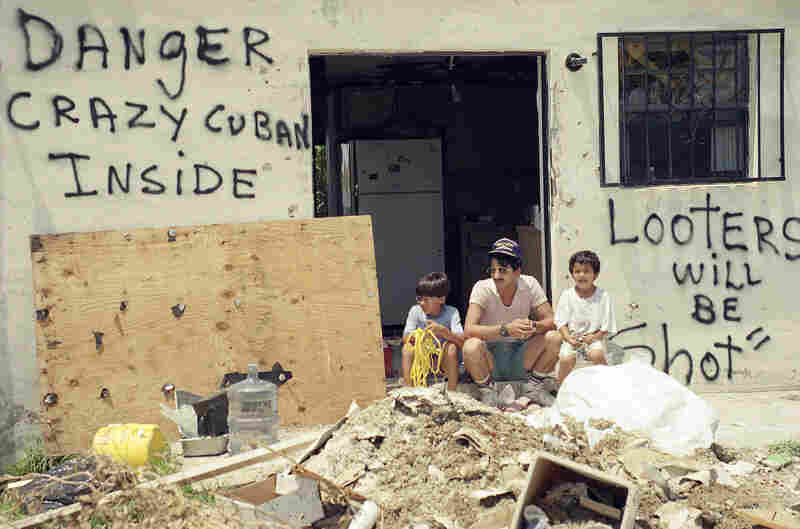 Orlando Somante sits with his sons Orlando (left) and Jonathan amid the rubble of their home in Cutler Ridge.