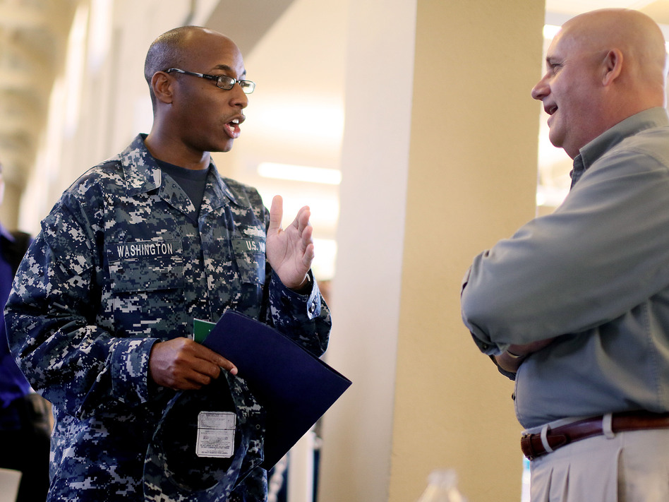 At a job fair in San Diego this week, Navy Sailor E-5 Cedric Washington spoke to Sim Garriotti from Lockheed Martin while interviewing for a potential position. (Sandy Huffaker/Getty Images)