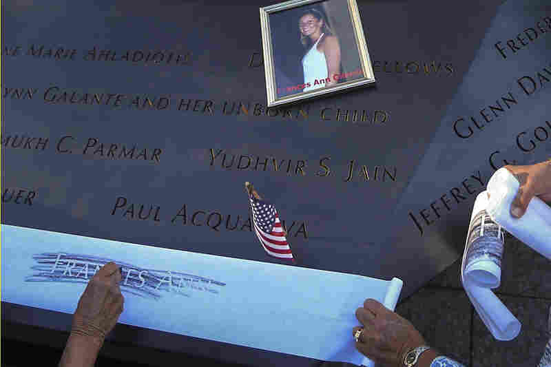 Judy Parisio (right) and Linda Malbrba make a rubbing of their niece's name, Frances Ann Cilente, who worked at the World Trade Center, during ceremonies marking the anniversary of the Sept. 11 attacks.