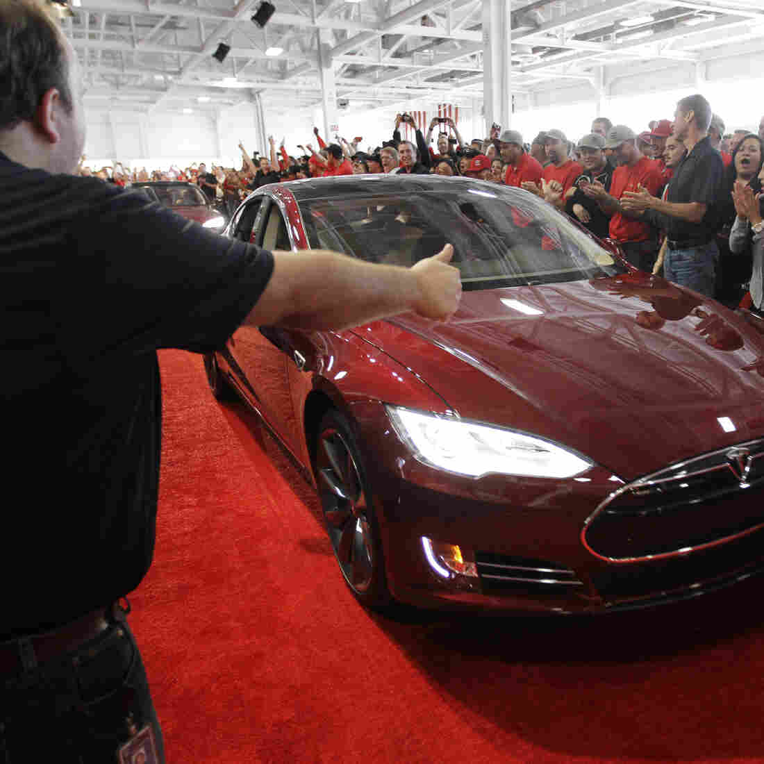 Tesla workers cheer on one of the first Tesla Model S cars sold, during a rally at the Tesla factory in Fremont, Calif., in June. The company is now unveiling a new network of refueling stations for the vehicles. Tesla workers cheer on one of the first Tesla Model S cars sold, during a rally at the Tesla factory in Fremont, Calif., in June. The company is now unveiling a new network of refueling stations for the vehicles.