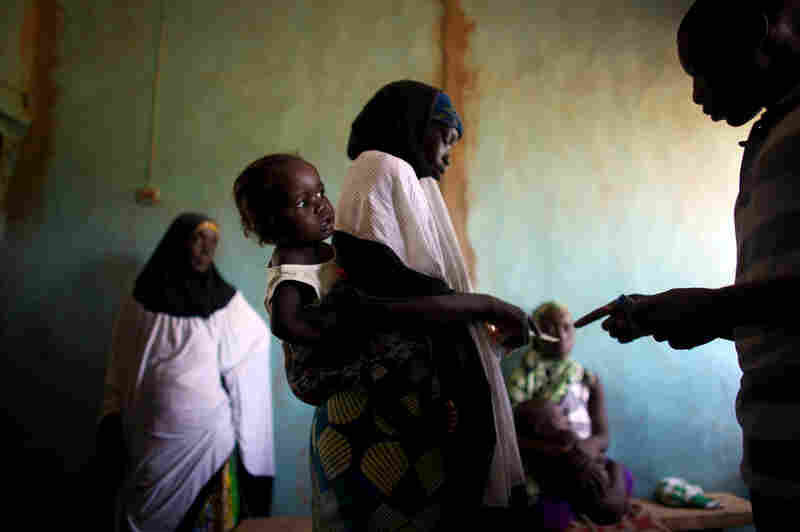 Women and their children wait for medication at the clinic in Dareta, Nigeria. Treating children with high levels of lead is a painstaking process that works only if their environment at home is free from lead.