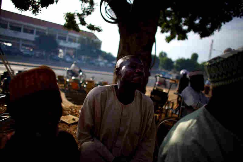 Men of all ages gather at a welding shop run by polio victims. The men make hand-cranked tricycles and customized motor scooters for people paralyzed by polio.