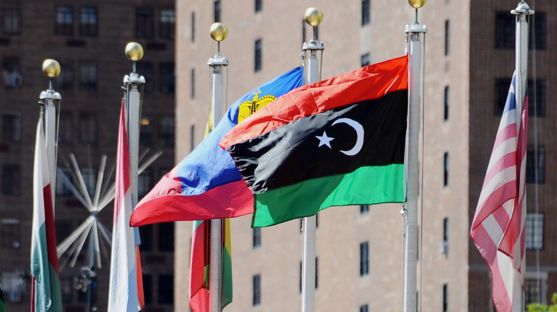 The flag of Libya's National Transitional Council (second from right) flies outside the United Nations headquarters building in New York. (Stan Honda/AFP/Getty Images)