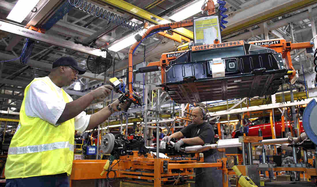 WAYNE, MI - DECEMBER 14: A worker demonstrates the installation of a battery pack for a Ford Focus on the assembly line at the Ford Motor Co.'s Michigan Assembly Plant December 14, 2011 in Wayne, Michigan.