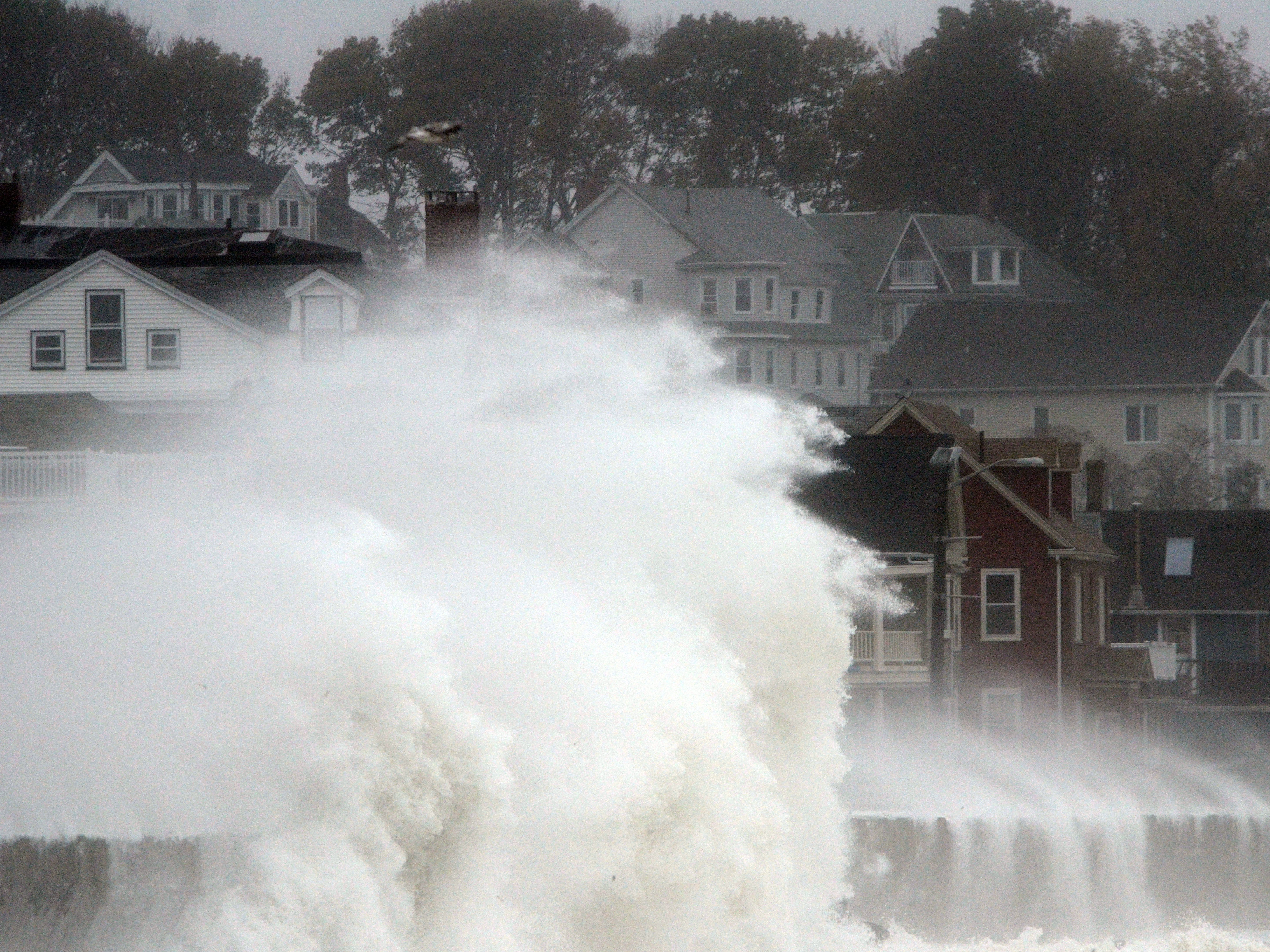 Waves crash over a road as Hurricane Sandy comes up the coast Monday in Winthrop, Mass. Economists are predicting the storm will cost tens of billions of dollars. (Getty Images)