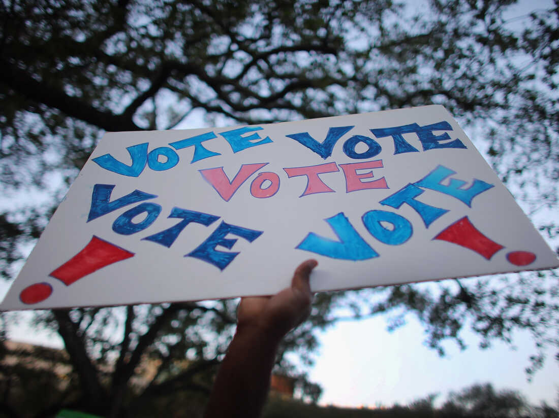 A sign reading "Vote" is held up during a rally for President Obama on Oct. 27 in Miami, Fla.