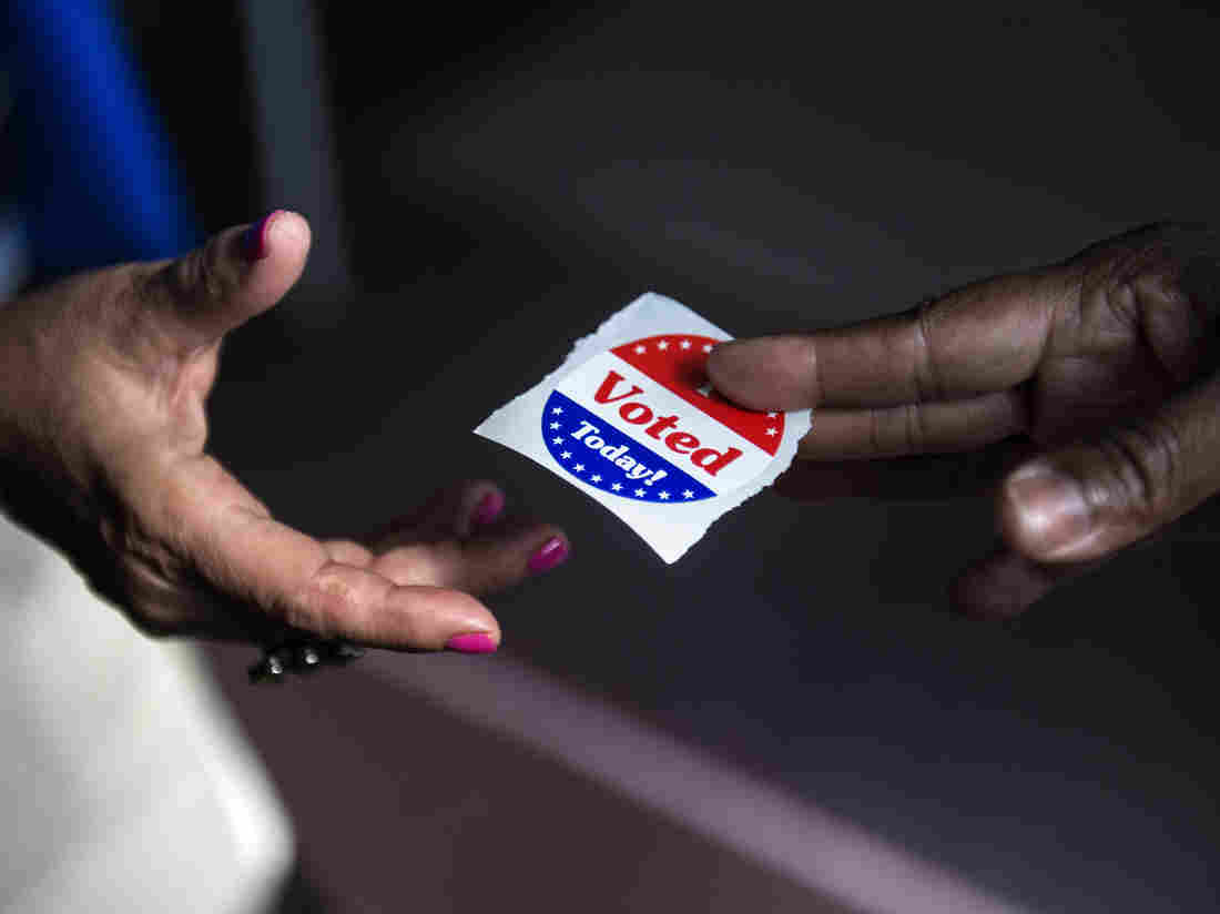 A poll worker hands out "I Voted Today" stickers during the first day of early voting October 22, 2012 in Washington, DC. Citizens of the District of Columbia began early voting today for the November 6th elections which will include the 2012 US Presidential election. AFP PHOTO/Brendan SMIALOWSKI (Photo credit should read BRENDAN SMIALOWSKI/AFP/Getty Images)
