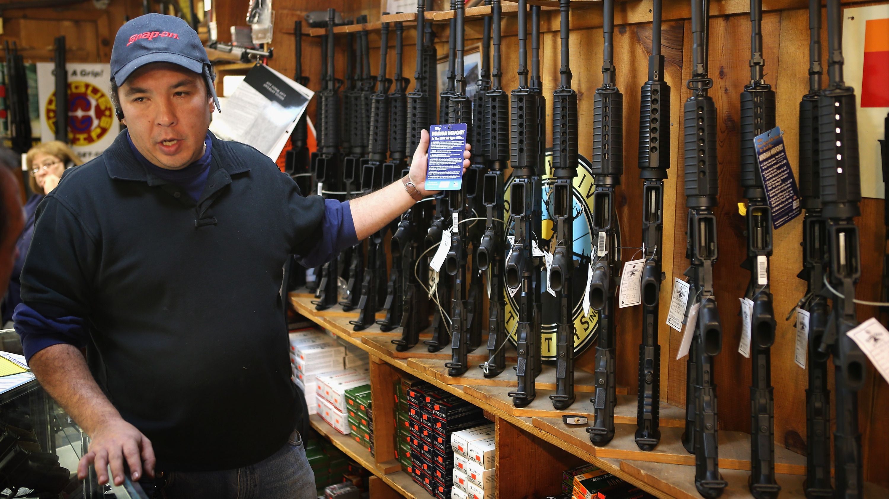 At the Freddie Bear Sports shop in Tinley Park, Ill., Jason Zielinski shows AR-15 style rifles to a customer. (Getty Images)