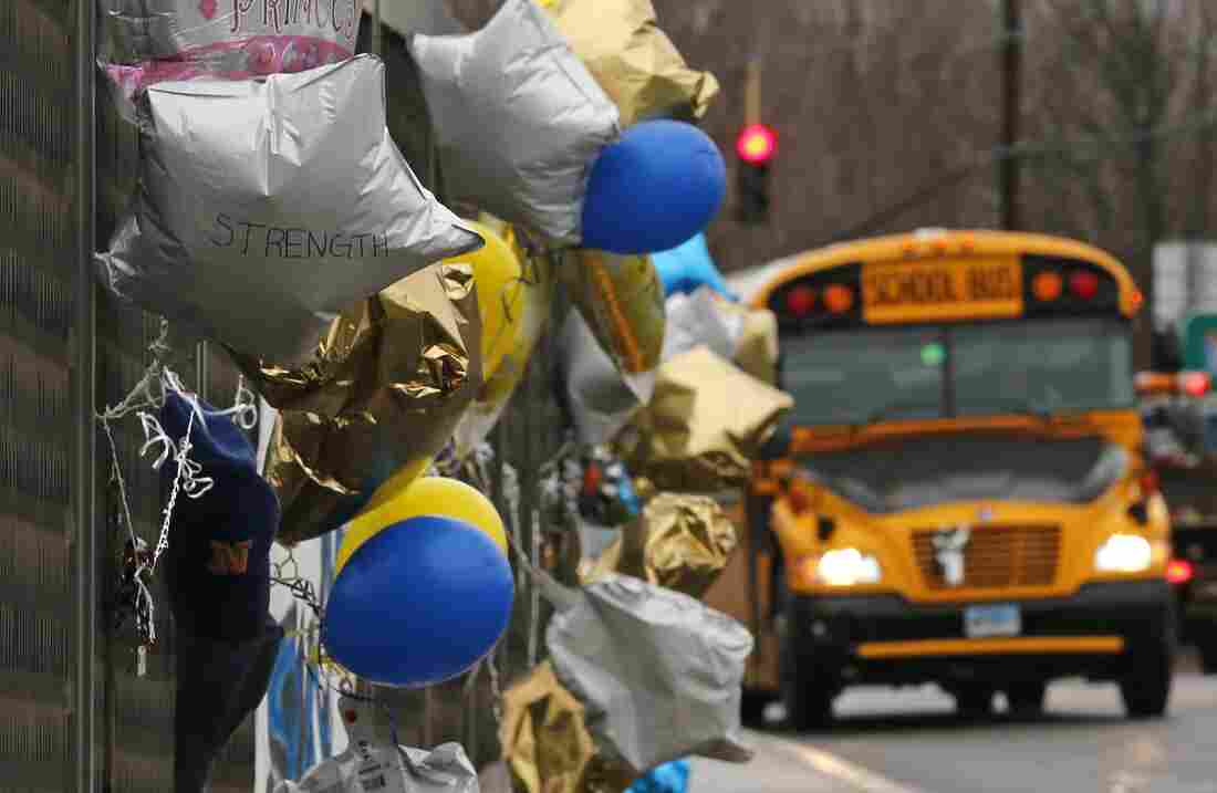A school bus rolls towards a memorial for victims of the school shooting in Newtown, Conn., Tuesday, Dec. 18, 2012.