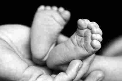 Baby feet held in parent's hand.