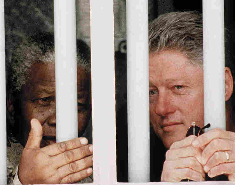 President Clinton and South African President Nelson Mandela peer out of the window of Mandela's former cell on Robben Island outside Cape Town, 1998. Mandela spent 18 of his 27 years as a political prisoner in this cell.
