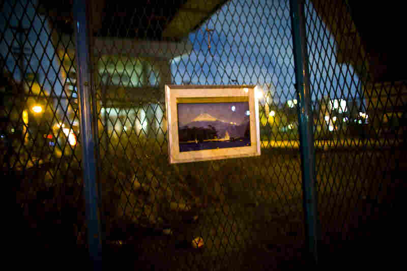 A picture of Mount Fuji hangs under a highway where a homeless man sleeps in Osaka, Japan.