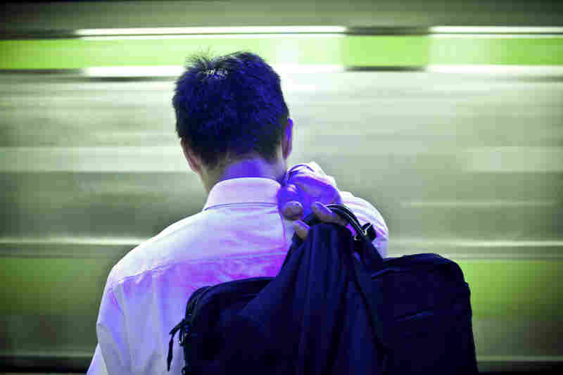 A Japanese businessman waits for a train under LED lights, which are designed to calm people and prevent them from jumping onto the tracks in Tokyo. Japan has one of the highest suicide rates in the world.