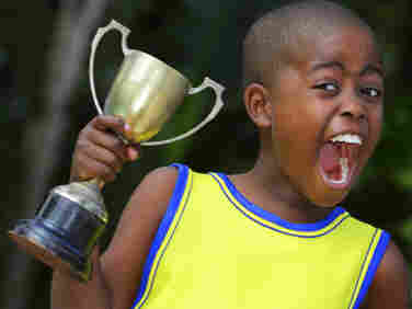 A young child shouts with joy after winning his sporting event.