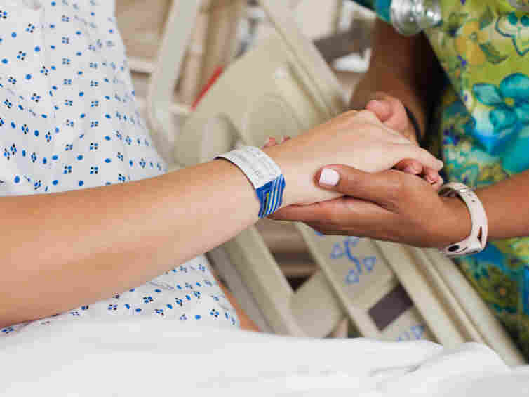 Nurse comforting patient in hospital