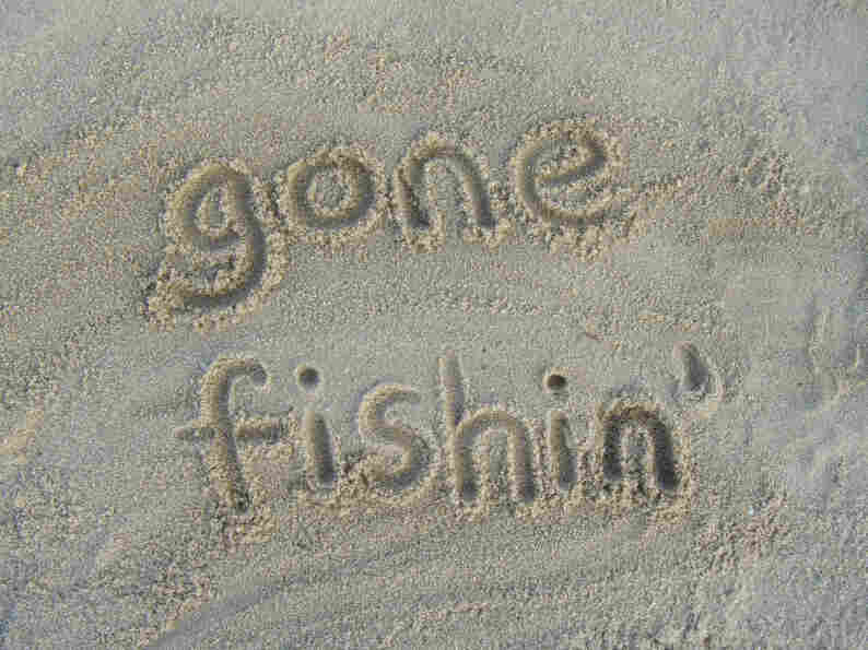 "Gone Fishin'" written in sand.