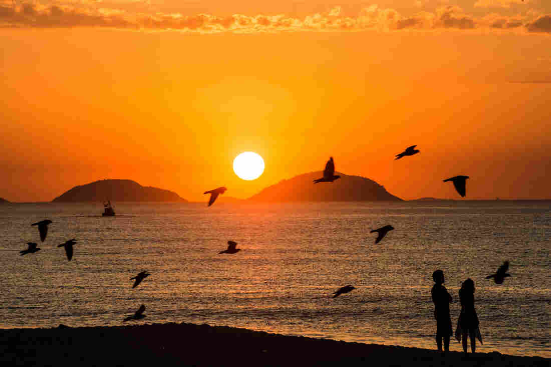 A couple watch the sunrise at Copacabana beach in Rio de Janeiro, Brazil, on Februrary 26, 2013.