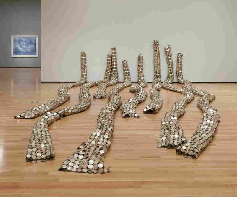 Sheets of linked milk tin lids were rolled into long, cylindrical forms to make Anatsui's Drainpipe (2010). 