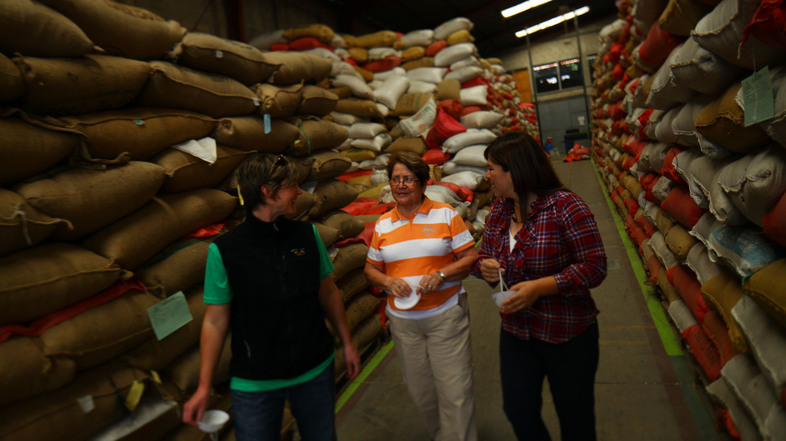 Three women in coffee leading the way: Stephanie Backus of Portland Roasting, coffee farmer Miguelina Villatoro of Guatemala, and coffee exporter/processor Loyreth Sosa. Here they discuss coffee prices as they survey beans ready for milling. (David Gilkey/NPR)