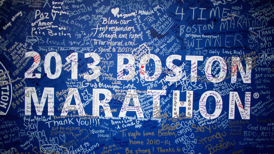 Signatures and messages adorn a Boston Marathon poster on Tuesday near the site of the April 15 bombings. (Mario Tama/Getty Images)