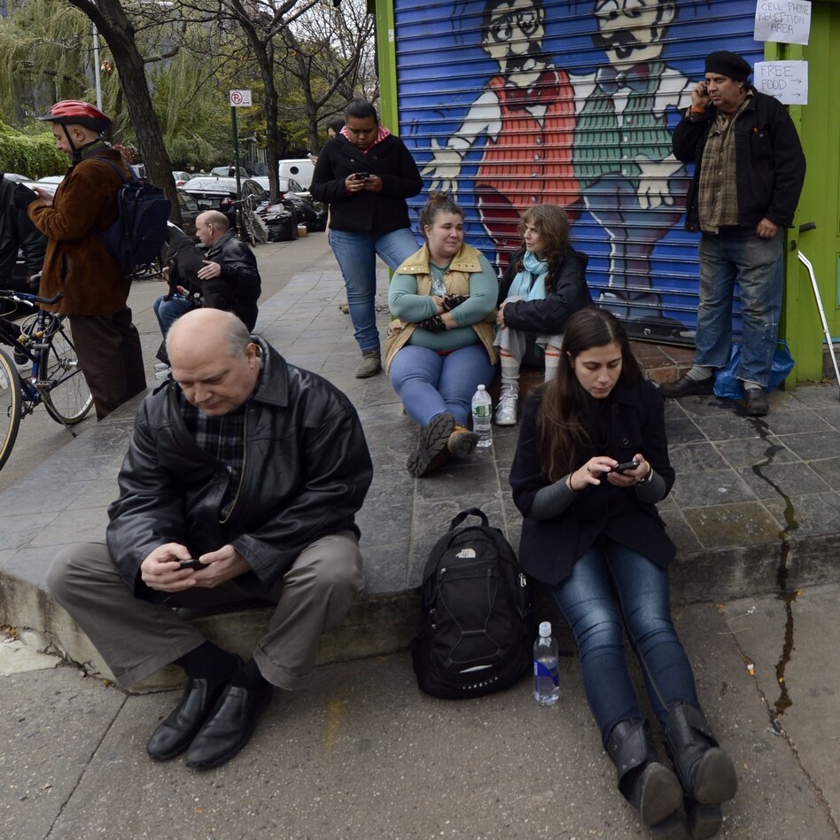 Residents of the East Village in New York City look for cellphone reception Nov. 1 after Hurricane Sandy wiped out power and some cell towers. (Timothy A. Clary/AFP/Getty Images)