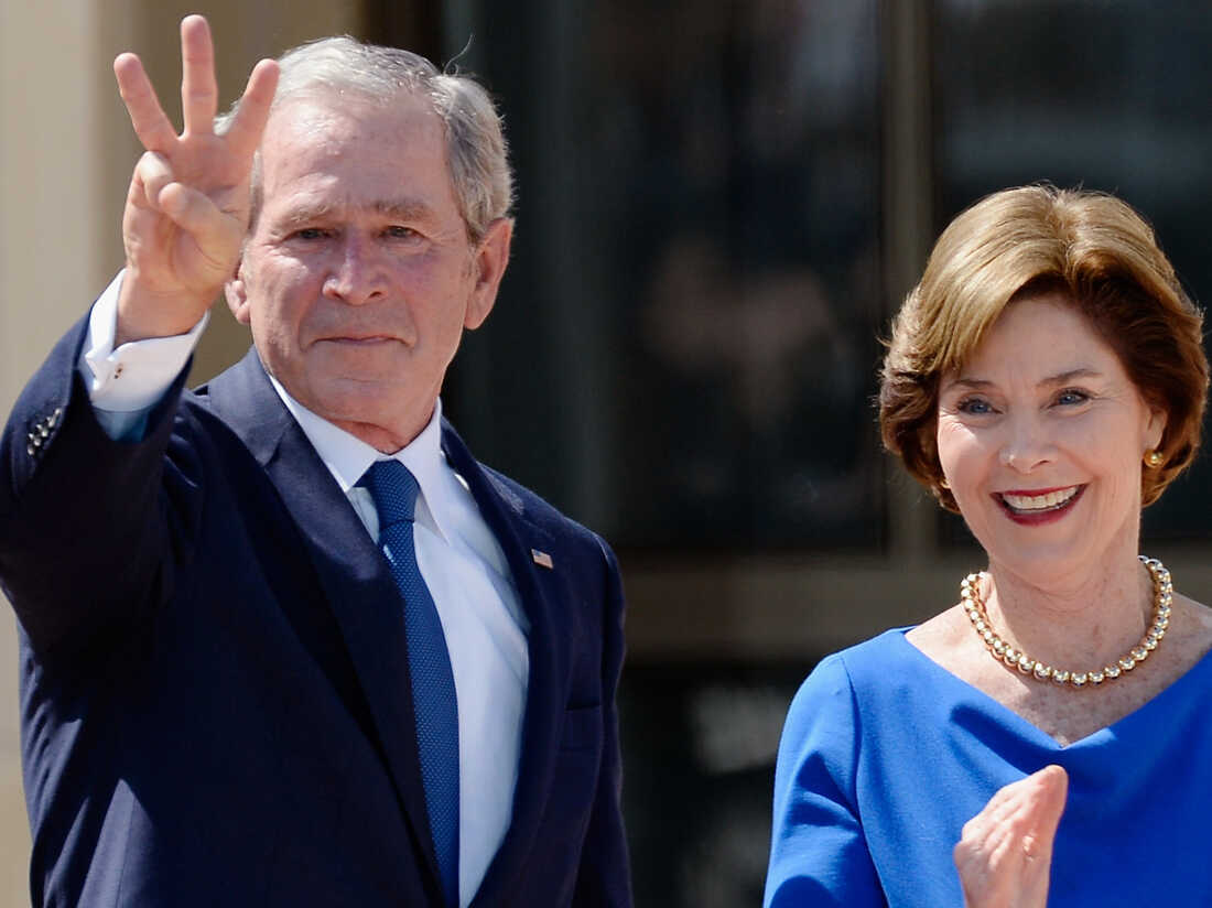 Former President George W. Bush shows three fingers for "W" with his wife, former First Lady Laura Bush, at the opening ceremony of the George W. Bush Presidential Center in Dallas on Thursday.