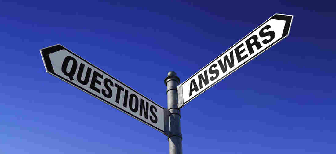 Street signs at an intersection. One says: questions. The other says: answers.