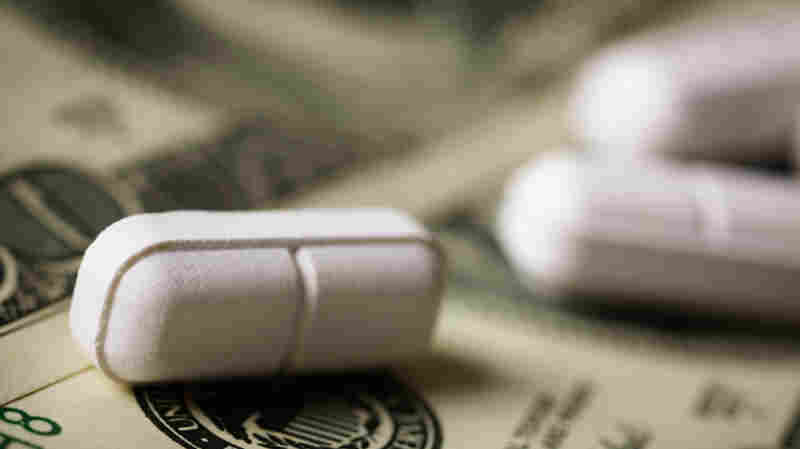 Scored tablets rest on U.S. currency.