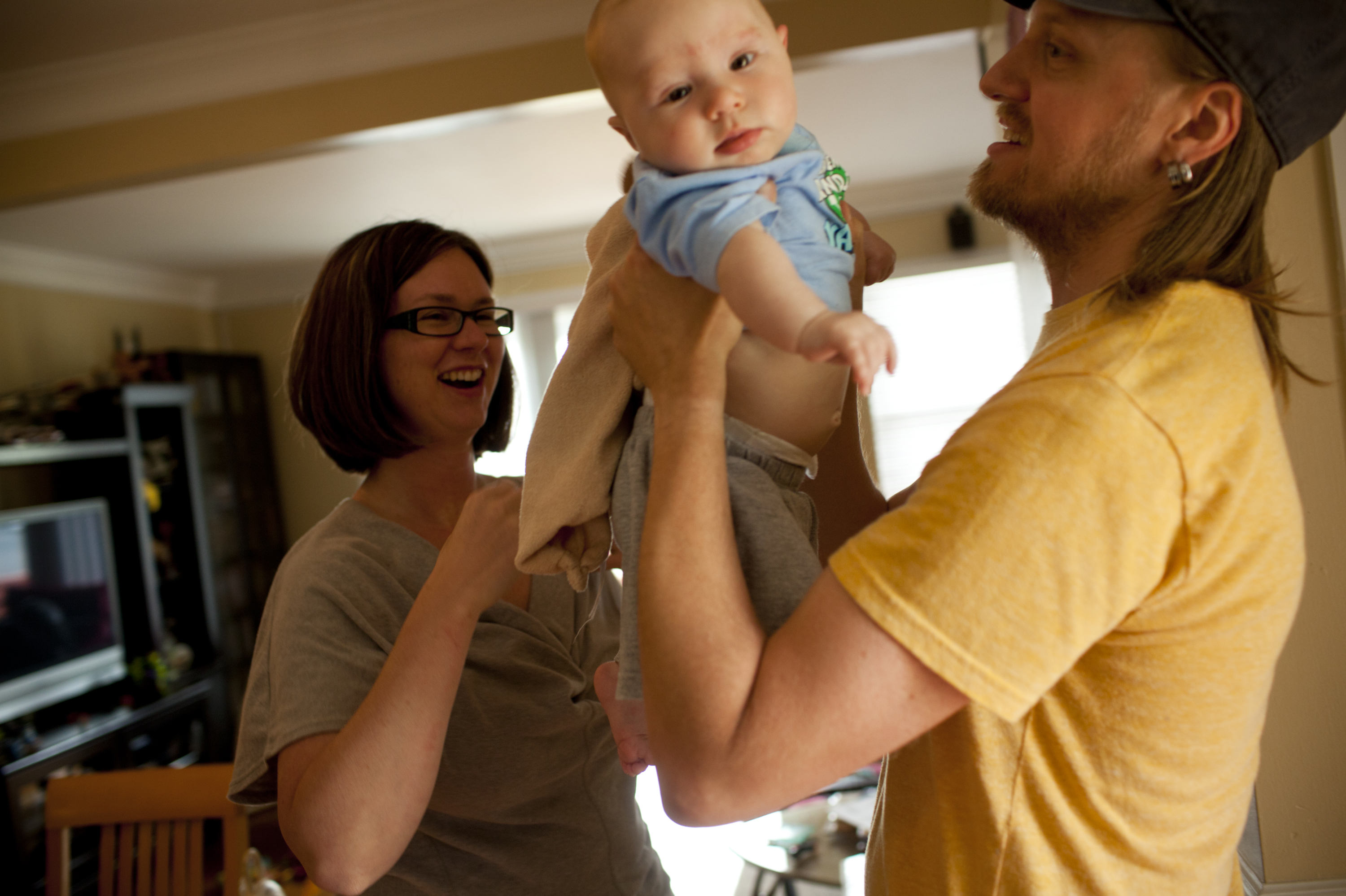 Dawn Heisey-Grove hands off Zane to Jonathan after a midday feeding. The couple were both working full time when Jonathan lost his job as a graphic designer two years ago. (Kainaz Amaria/NPR)