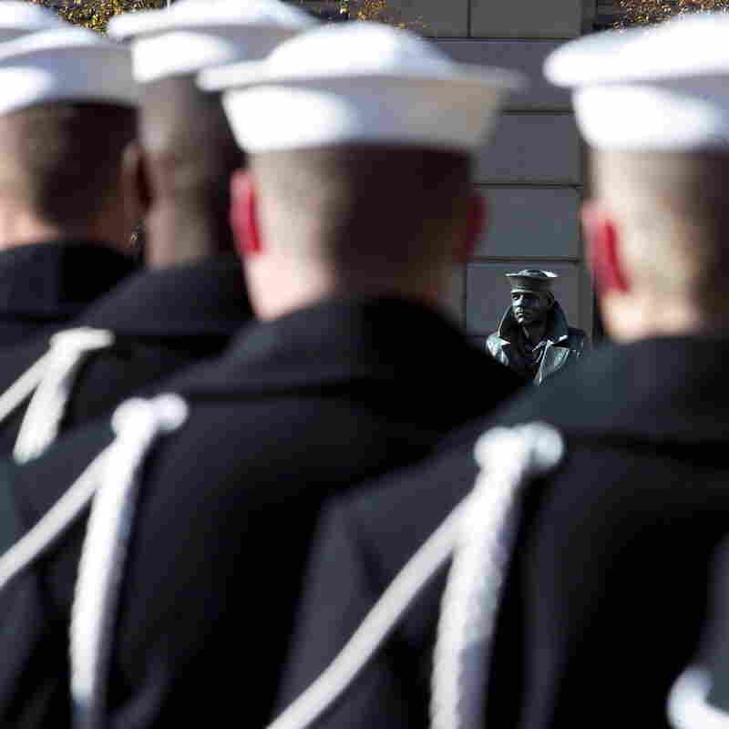 U.S. Navy sailors form a ceremonial guard at a wreath-laying ceremony to memorialize the victims of the attack on Pearl Harbor and pay tribute to the veterans of World War II in front of the Lone Sailor statue at the Naval Memorial in Washington, D.C., in December 2003.