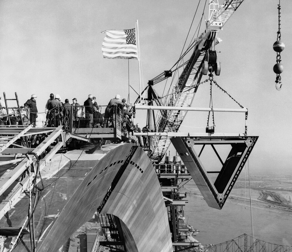 Workmen bring the keystone section into place on Oct. 28, 1965. The crane in the background lifted the 10-ton stainless steel section. The Mississippi River is to the right.