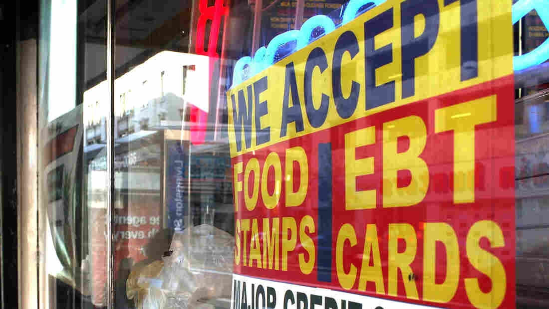 A sign in a New York City market window advertises that it accepts food stamps.