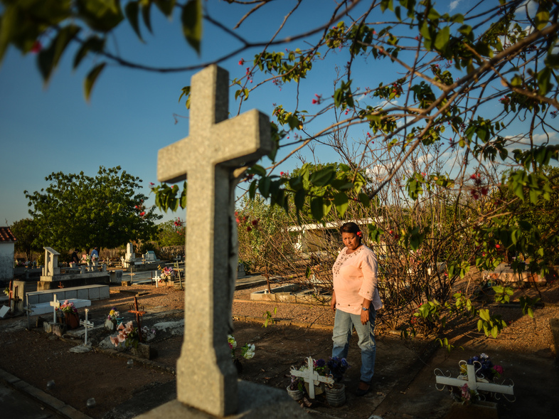 Eloisa Barrios visits the humble graves of nine male family members in the Guanayen cemetery. She says all nine were killed by the police, in what was a vendetta against her family. Recently, a 10th member of the family was stabbed to death. He was 17. (Meridith Kohut for NPR)