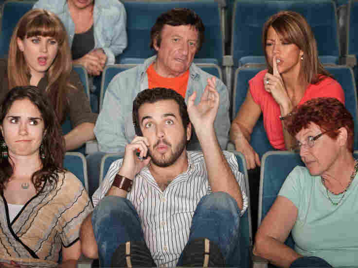 Man on the phone in a theater.