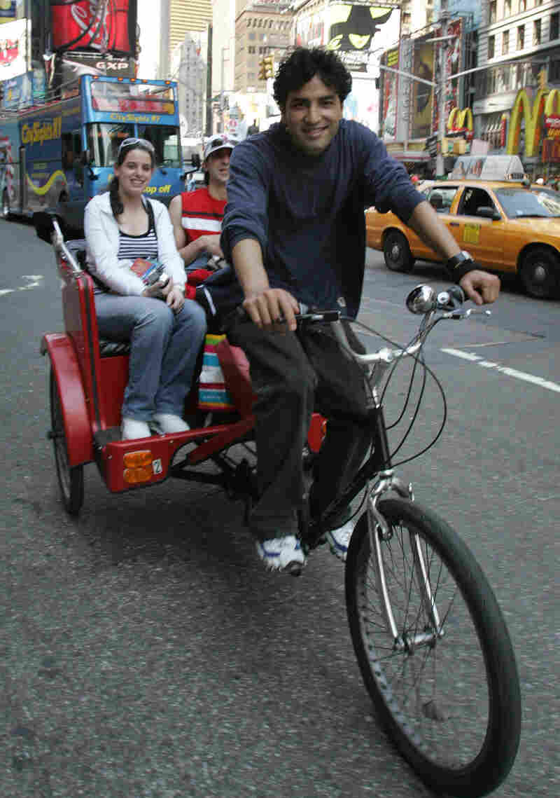 A pedicab rider takes tourists on a ride through Times Square in 2006.