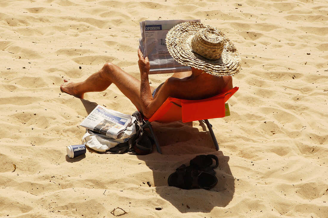 A man reads a newspaper on Balmoral beach in Sydney, Australia, in 2009.