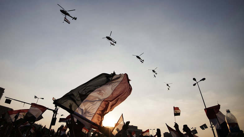 Egyptians wave their national flag as army helicopters fly over Cairo's Tahrir Square on July 4, the day after the military ousted President Mohammed Morsi. Egypt's military receives $1.3 billion annually from the U.S. (Gianluigi Guercia/AFP/Getty Images)