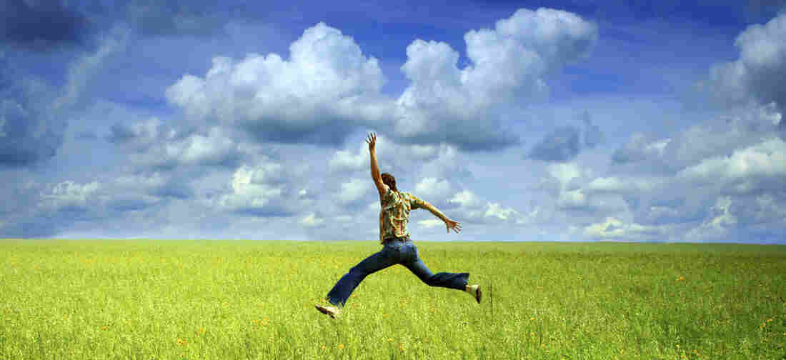 A man jumping in a green field.