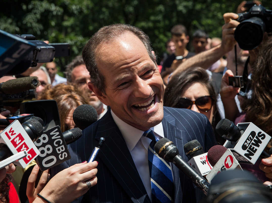 Former New York Gov. Eliot Spitzer is mobbed by reporters while attempting to collect signatures to run for comptroller of New York City on July 8.