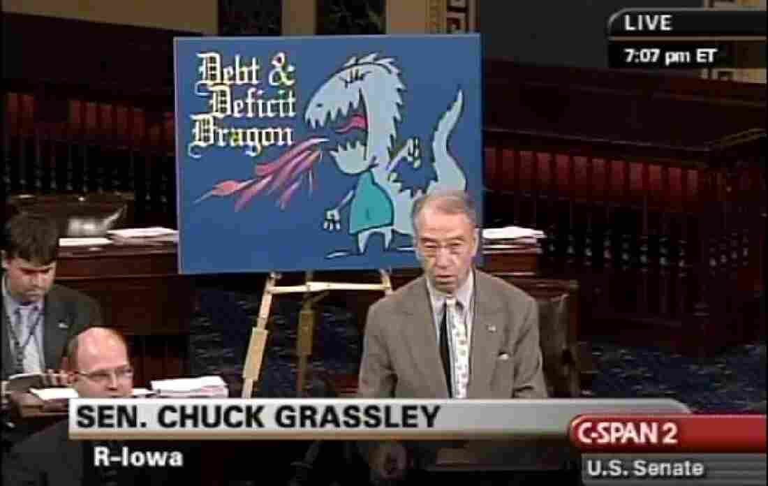 Sen. Charles Grassley (R-Iowa) with a debt and deficit dragon floor chart.