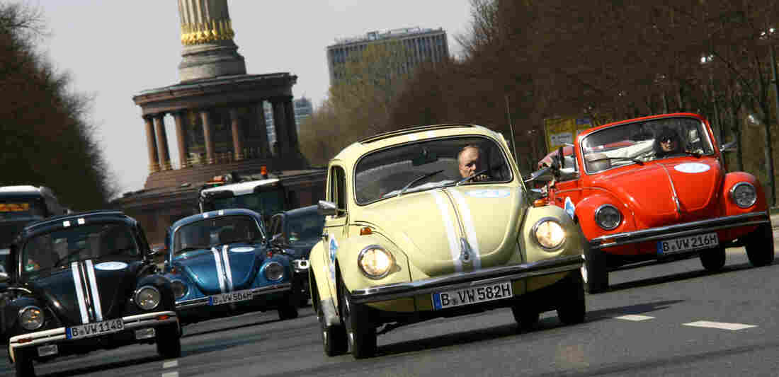 Beetle cars of German car maker Volkswagen (VW) drive past Berlin's landmark the Victory Column on April 23, 2013, in Berlin to promote a new tourist attraction.