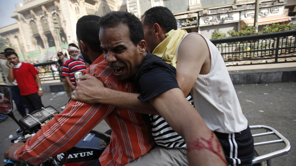 Supporters of the deposed Egyptian president, Mohammed Morsi, carry an injured demonstrator who was shot during clashes in Ramses Square in Cairo on Friday. Dozens were killed nationwide in escalating violence. (AMR ABDALLAH DALSH/Reuters /Landov)