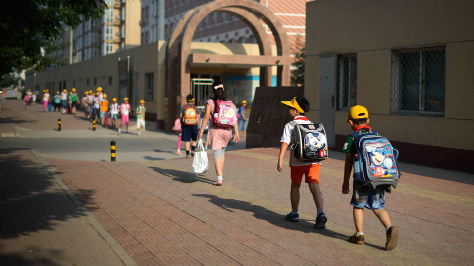 In the hopes of easing pressures on China's students, the country' education officials are considering a ban on written homework. Here, students walk to school in Beijing in June. (Ed Jones/AFP/Getty Images)