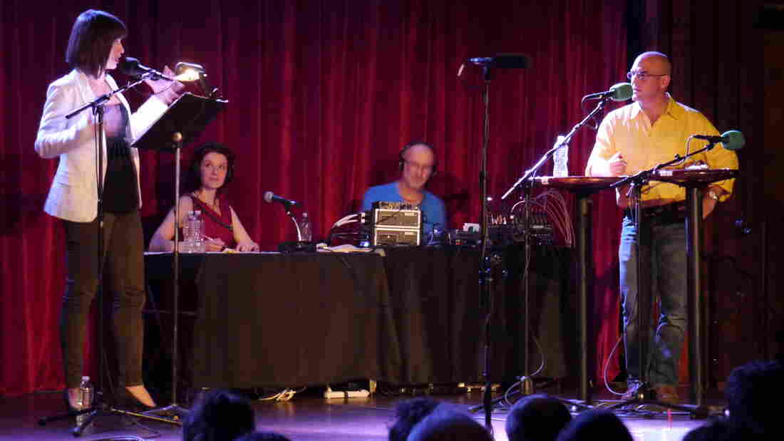 Wait, Wait...Don't Tell Me! host Peter Sagal stands poised and ready for the next perplexing question from Ask Me Another host Ophira Eisenberg, on stage at The Bell House in Brooklyn, NY.