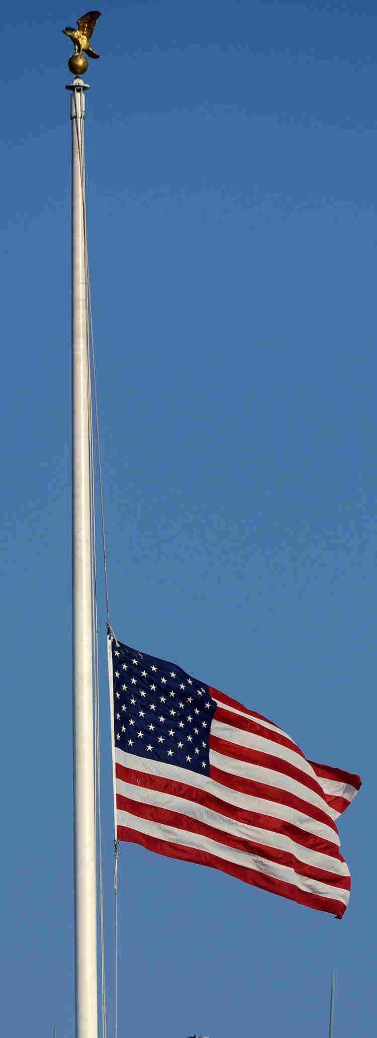 The American flag flies at half-staff atop the White House on Monday.