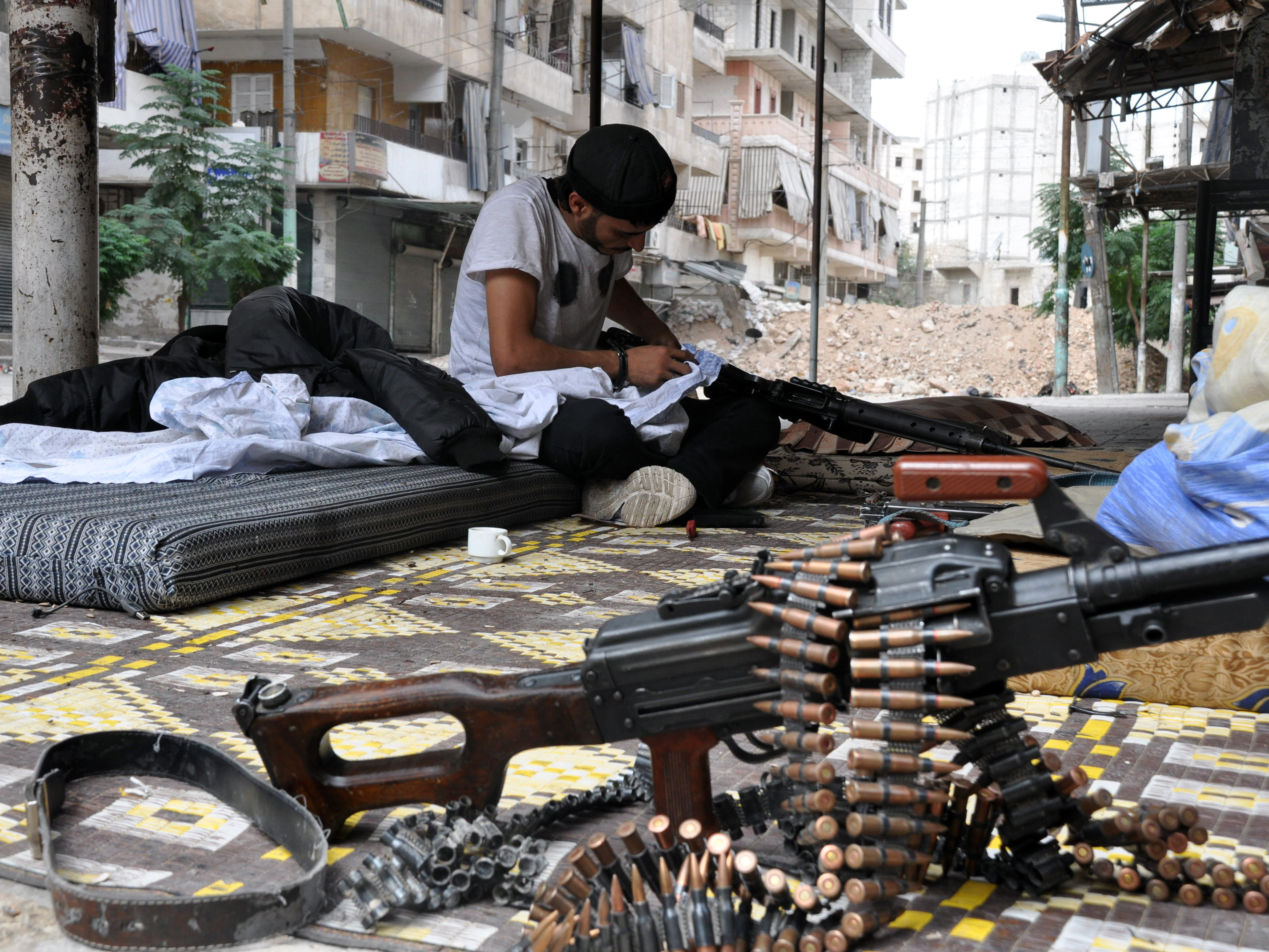 A rebel fighter cleans his weapon in the northern Syrian city of Aleppo Friday. Syria's civil war continues, even as the country follows a schedule of releasing information on its chemical weapons program.