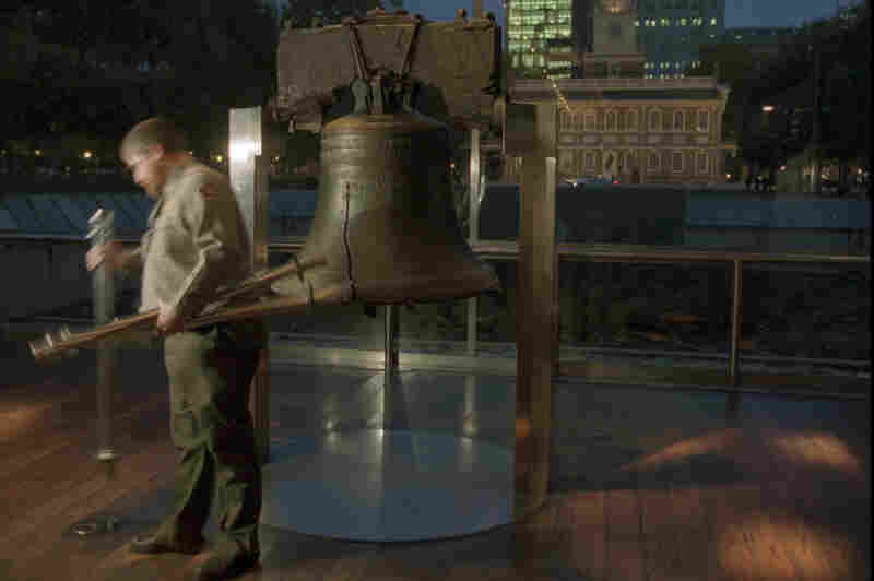 With Philadelphia's Independence Hall in the background, Park Service employee Matt Ifill gathers up the poles that surround the Liberty Bell at closing time on Dec. 13. With many government services scheduled to close down at midnight, Ifill and other workers there planned to report to work but were uncertain as to what they would do.