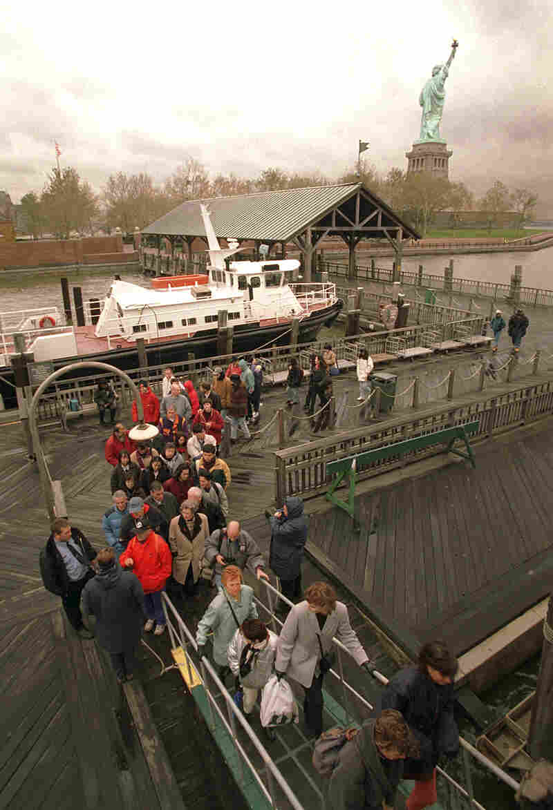 Tourists board the ferry, with the Statue of Liberty in the background, after being asked to leave Liberty Island in New York Harbor on Nov. 14.