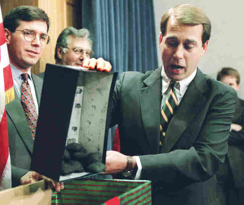 Rep. John Boehner, R-Ohio, dumps out coal, which he called a Christmas gift to President Clinton, during a Dec. 21 Capitol Hill news conference. The White House and congressional Republicans labored to restart balanced budget talks.